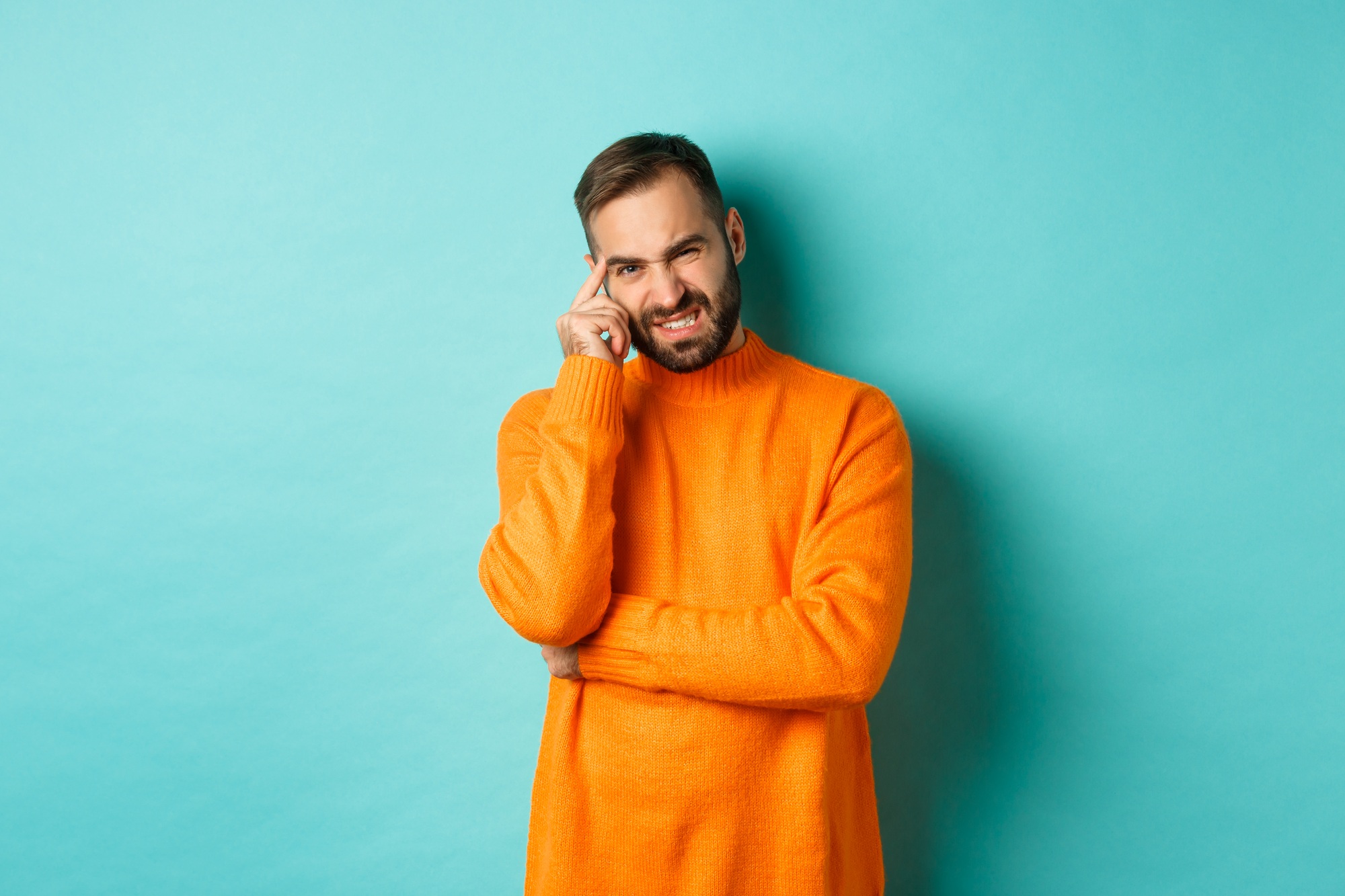 Man with beard, grimacing and cringe from something embarrassing, looking with awkward face